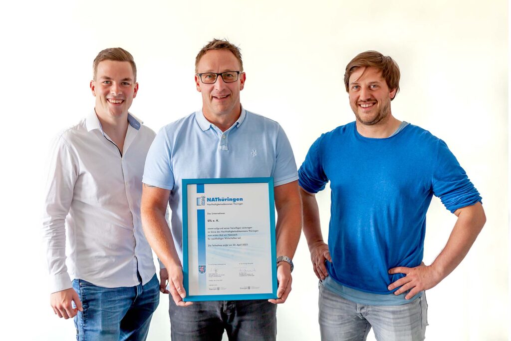 Fabian, André und Christopher Heimrich präsentieren die Urkunde über die Teilnahme am Thüringer Nachhaltigkeitsabkommen